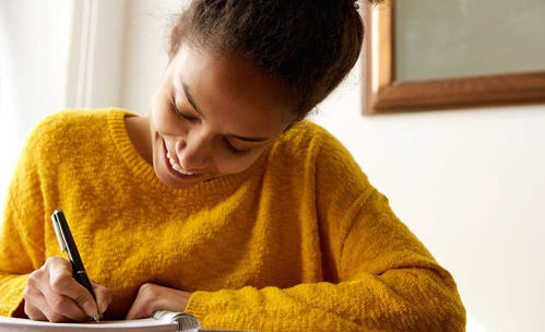 Smiling woman writing in a book