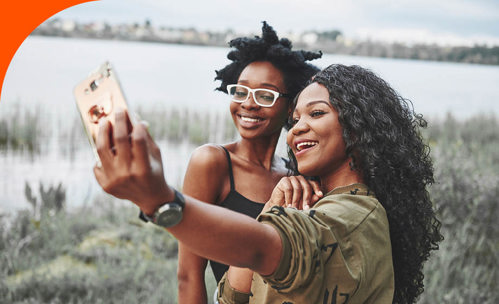 Young adults smiling and taking selfie.