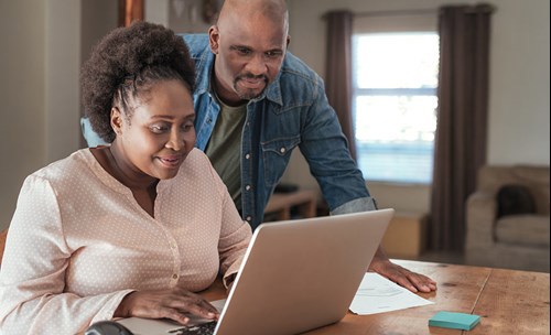 Man and woman looking at and using laptop